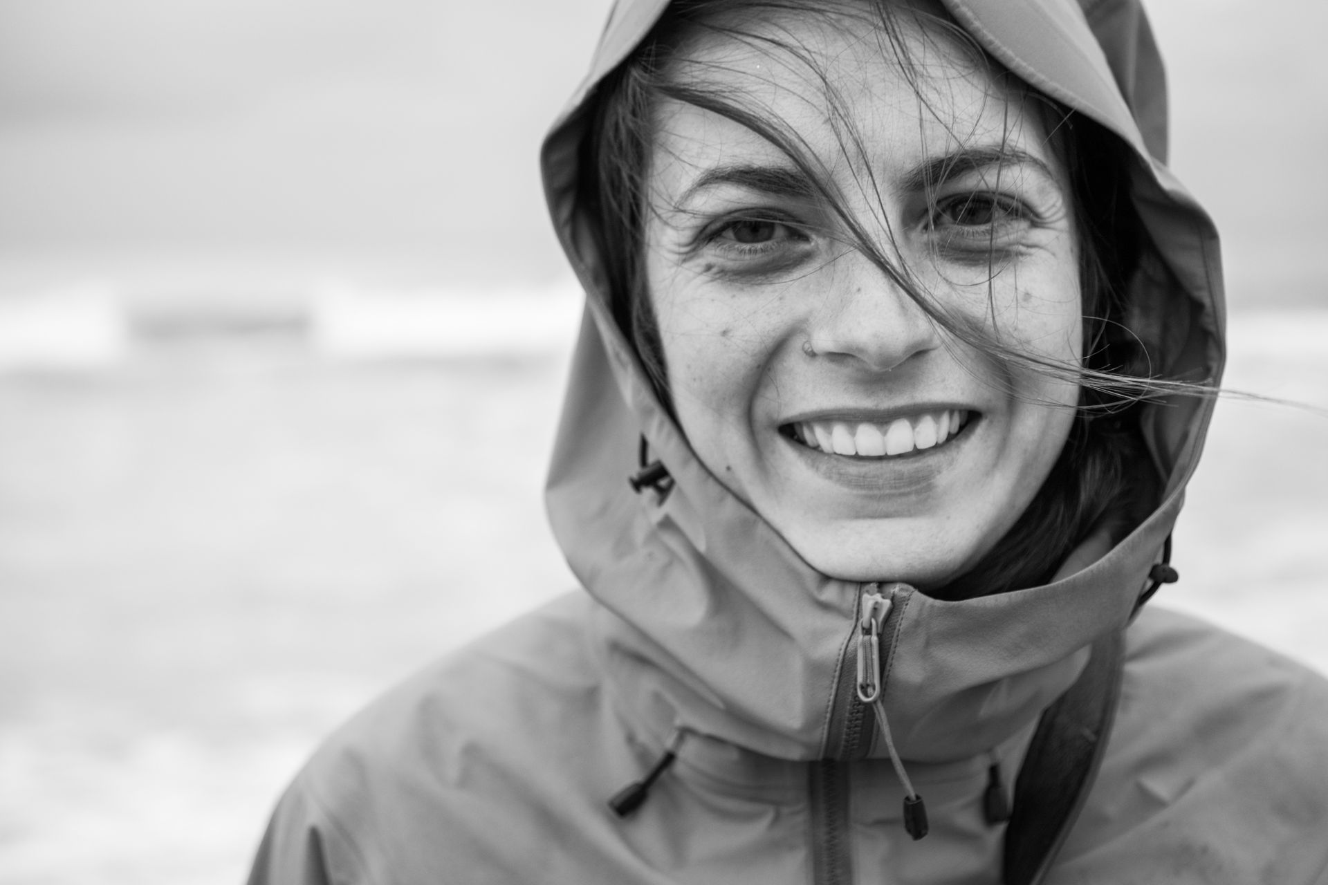 Cristina lacht in die Kamera, die Kapuze ihrer Regenjacke auf